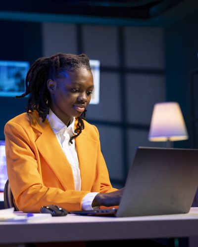 Freelancer at desk working from home in apartment office solving business related tasks on laptop. Remote employee sitting down in living room, sending emails on notebook